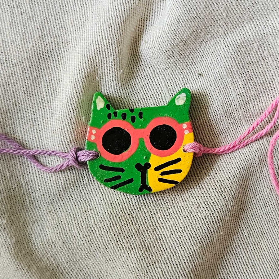 Handpainted Quirky Wooden Rakhi With Roli Chawal 16 - Close-up of single cat bracelet