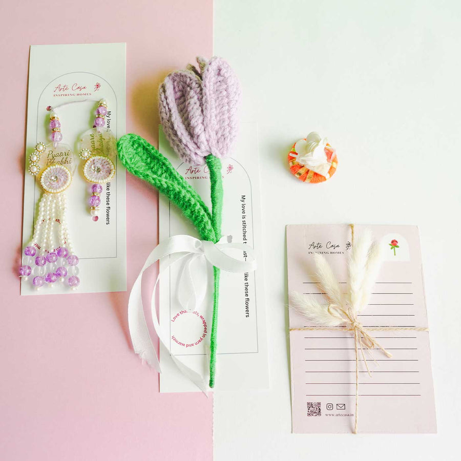 Personalized Handmade Crochet Tulip Light Purple Rakhi Hamper Includes 1 Crochet Flower 1 Message Card And 2 Rakhis And Roli Chawal - Flat Lay Display of Accessories