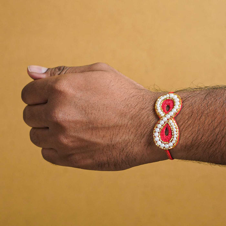 Handmade Beaded Infinity Rakhi With Roli Chawal - Worn on Wrist View