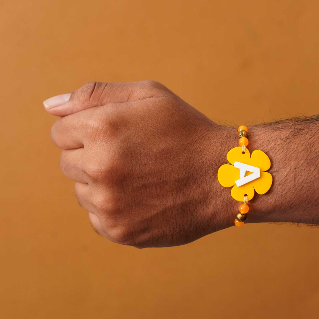 Personalized Handmade Alphabet Flower Acrylic Rakhi With Roli Chawal - On wrist showing fit (6)