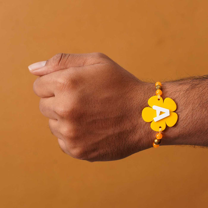 Personalized Handmade Alphabet Flower Acrylic Rakhi With Roli Chawal - On wrist showing fit (6)