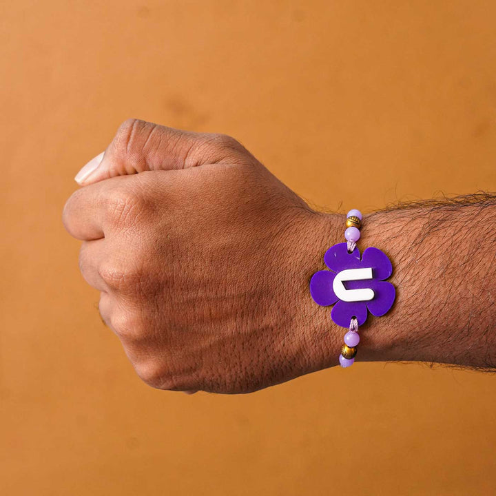 Personalized Handmade Alphabet Flower Acrylic Rakhi With Roli Chawal - On wrist showing fit (9)