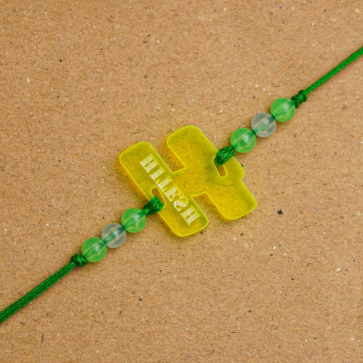 Personalized Handmade Alphabet Name Acrylic Rakhi With Roli Chawal - Close-up of Green Rakhi