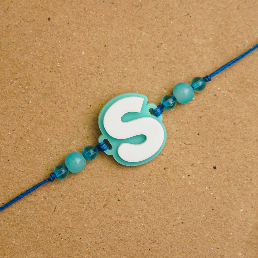 Personalized Handmade 3D Alphabet Acrylic Rakhi With Roli Chawal - Letter S Close-up on Surface
