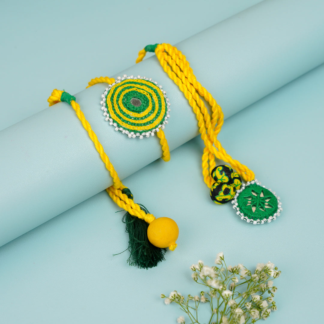 Handmade Reusable Yellow And Green Mirror And Jhumki Cotton Rope Rakhi For Bhaiya And Bhabhi - Rolled Display with Charms