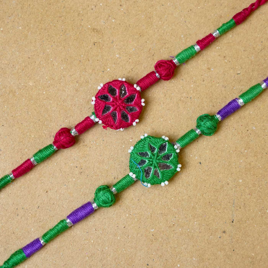 Handmade Mirror Work Patwa Maroon Green Cotton Rakhi With Roli Chawal Set Of 2 - Close-up of two rakhis