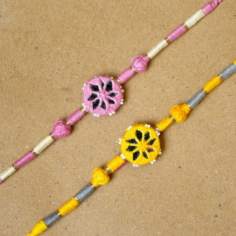 Handmade Mirror Work Patwa Pink Yellow Cotton Rakhi With Roli Chawal Set Of 2 - Close-up of two bracelets