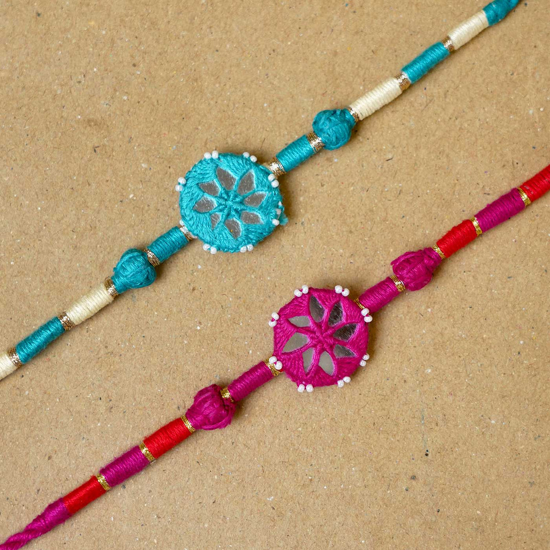 Handmade Mirror Work Patwa Turquoise Blue Pink Cotton Rakhi With Roli Chawal Set Of 2 - Close-up of two Rakhis