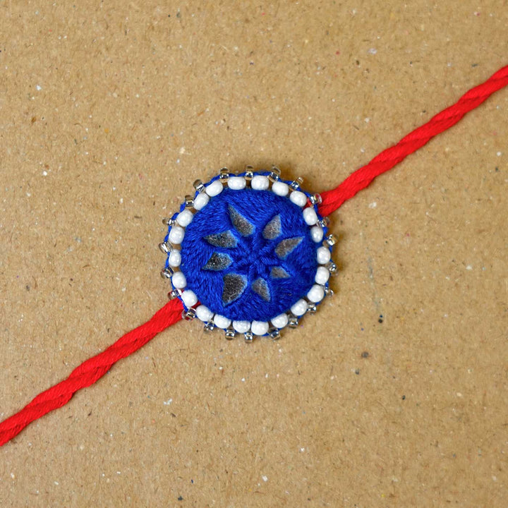 Handmade Mirror Work Kajal Blue Red Rakhi With Roli Chawal - Close-up of single rakhi