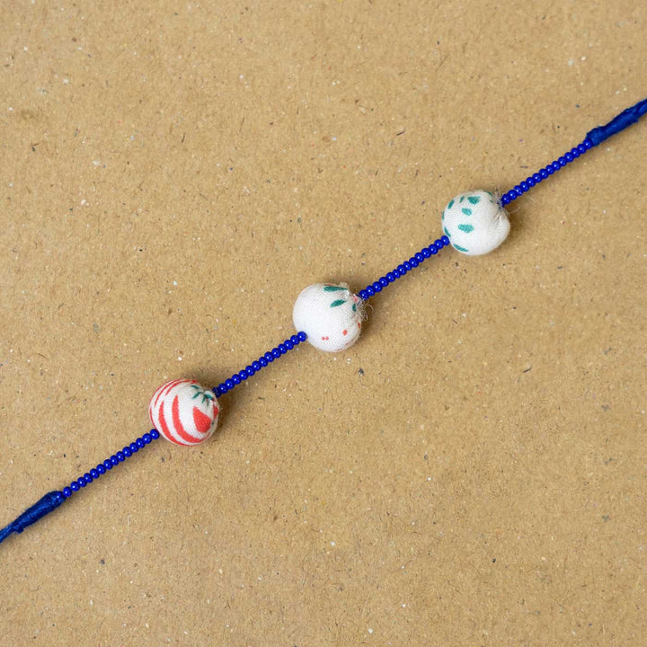 Handmade Shweth Potli Upcycled Fabric Rakhi With Roli Chawal - Close-up of bracelet beads