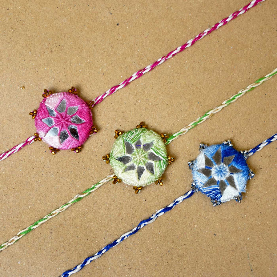 Handmade Mirror Work Kaanha Assorted Colours Cotton Rakhi With Roli Chawal Set Of 3 - Close-up of three bracelets