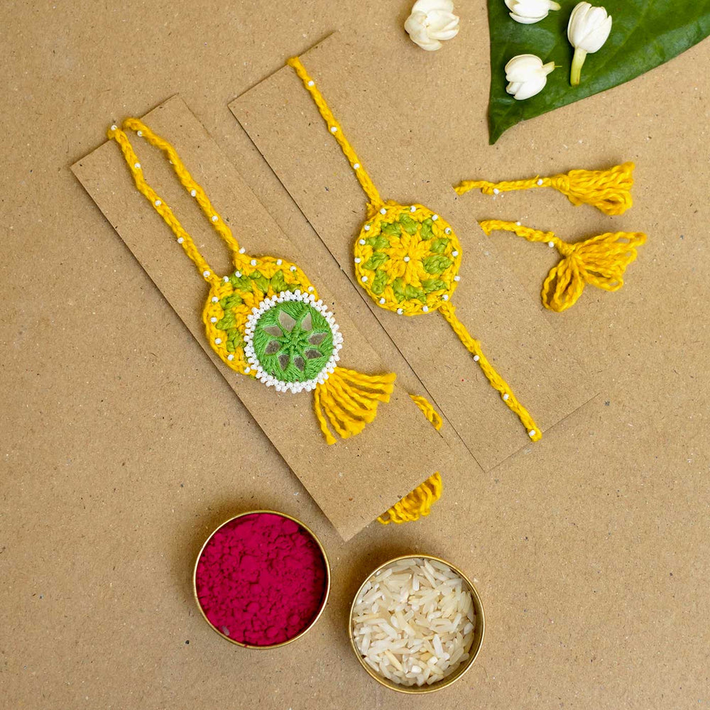 Handmade Crochet Mirror Blossom Bhaiya Bhabhi Rakhi With Roli Chawal Set Of 2 - Flat Lay with Festival Items
