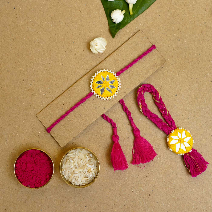 Handmade Mirror Work Kajal Yellow Red Bhaiya Bhabhi Rakhi With Roli Chawal Set Of 2 - Flat Lay with Rakhi and Accessories