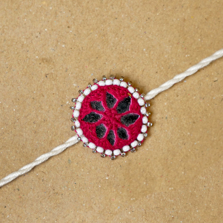Handmade Mirror Work Kajal Maroon White Cotton Rakhi With Roli Chawal - Close-up of Rakhi centerpiece