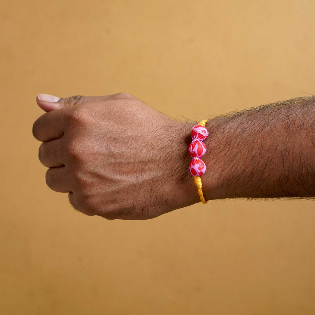 Handmade Ochre Upcycled Fabric Rakhi With Roli Chawal - On Wrist Display
