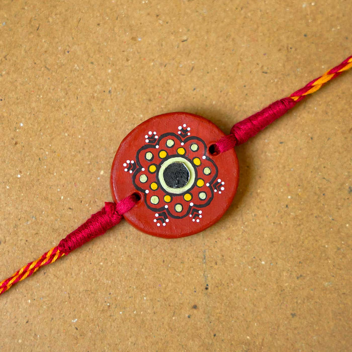 Hand Painted Dharti Terracotta Rakhi With Roli Chawal - Close-up of Rakhi centerpiece