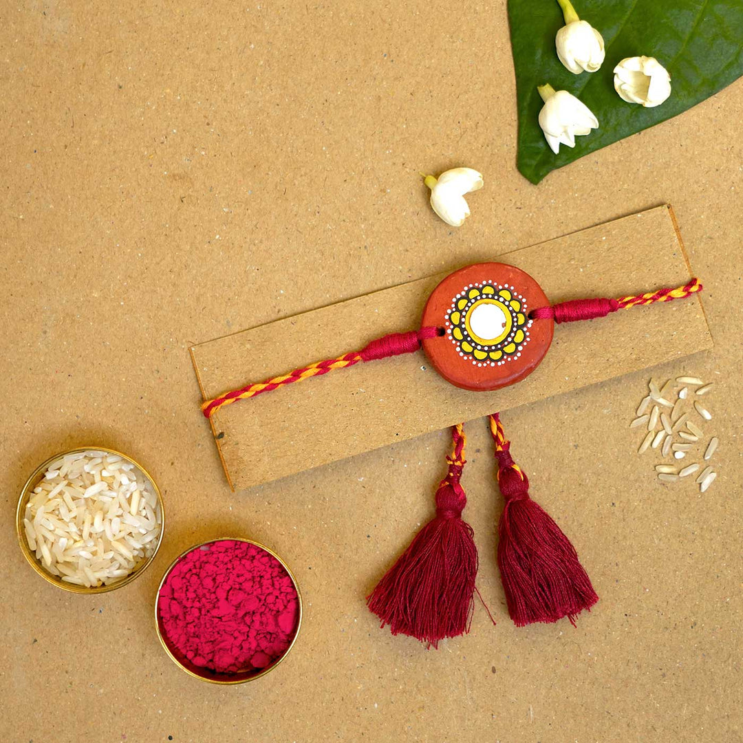 Hand Painted Suraj Terracotta Rakhi With Roli Chawal - Rakhi on display card