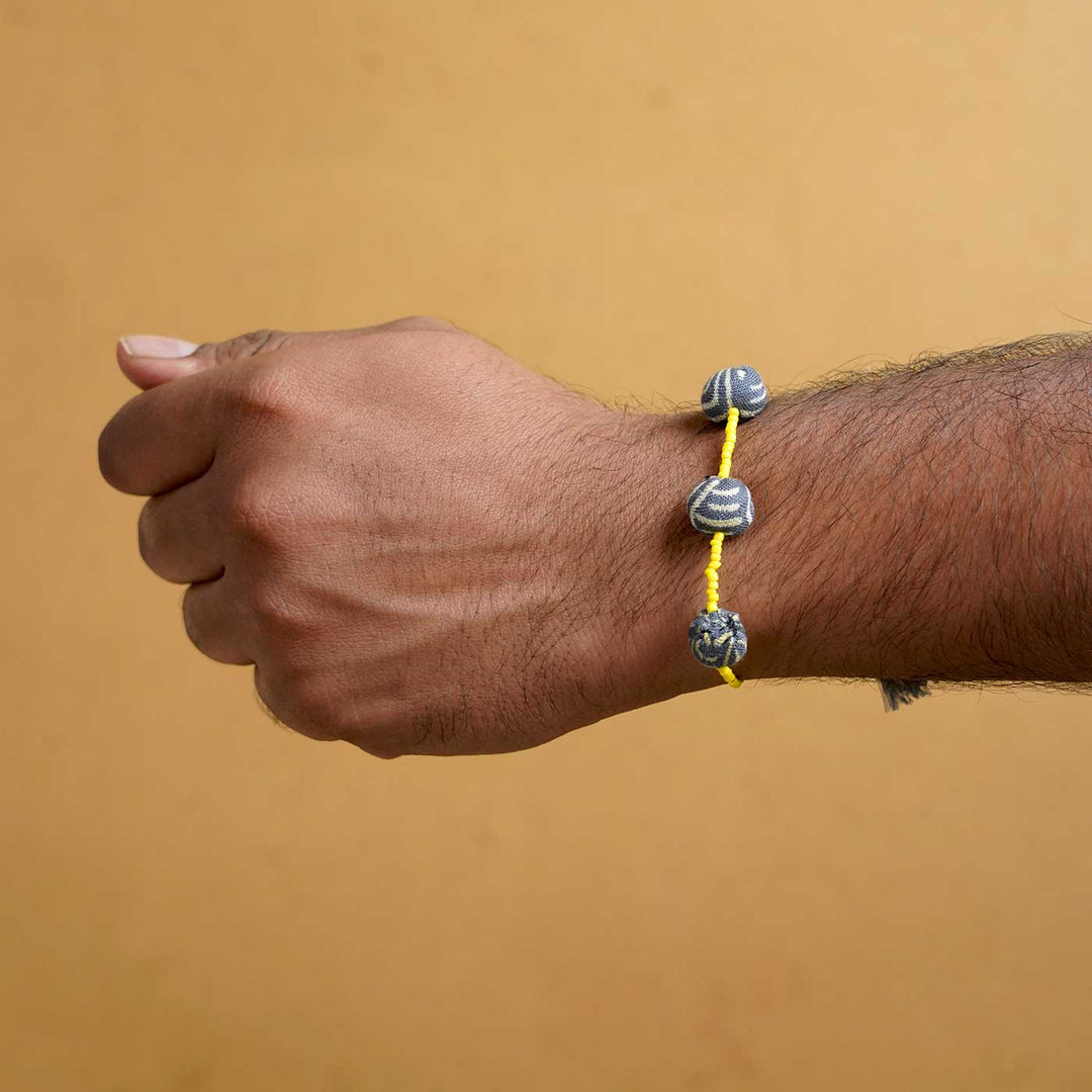 Handmade Swarnamukhi Potli Upcycled Fabric Bhaiya Bhabhi Rakhi With Roli Chawal Set Of 2 - Single Wrist Close-up View