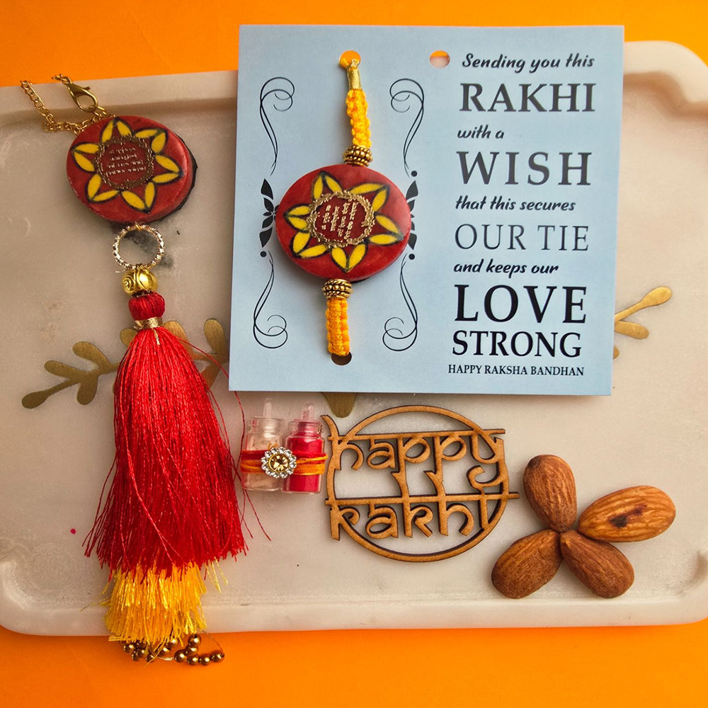 Handmade Red Gayatri Mantra Ceramic Bhaiya Bhabhi Rakhi With Roli Chawal - Close-up of Rakhi and Card