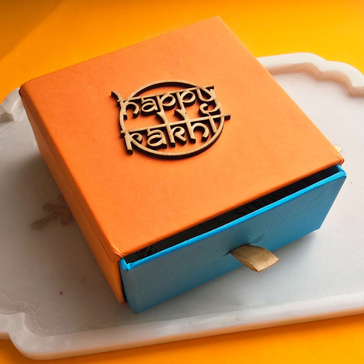 Handmade Red Gayatri Mantra Ceramic Bhaiya Bhabhi Rakhi With Roli Chawal - Packaging Box with Happy Rakhi Decor