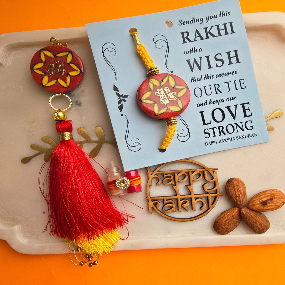 Handmade Laser Cut Red Jai Shree Krishna Ceramic Bhaiya Bhabhi Rakhi With Roli Chawal - Close-up of Rakhi and Card