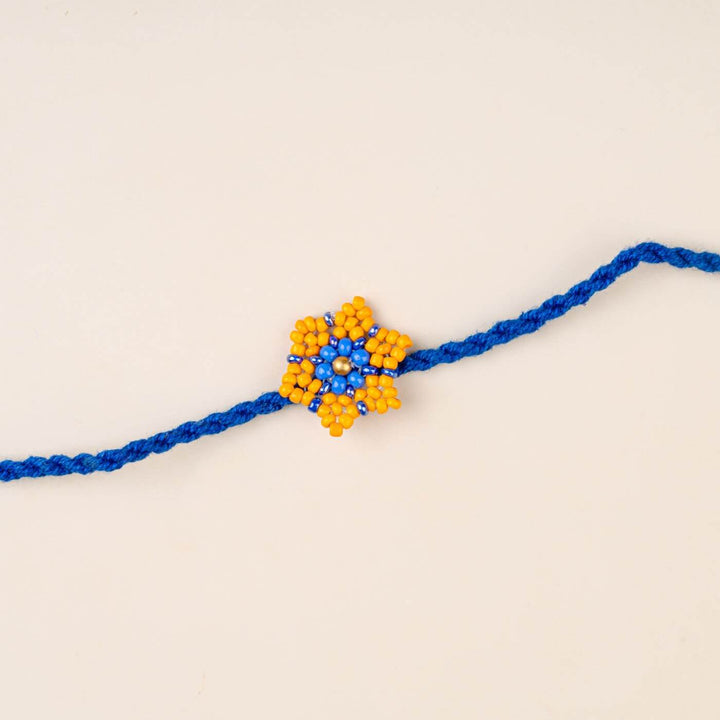 Handcrafted Glass Beads Sitara Rakhi 7 - Close-up of blue and yellow rakhi