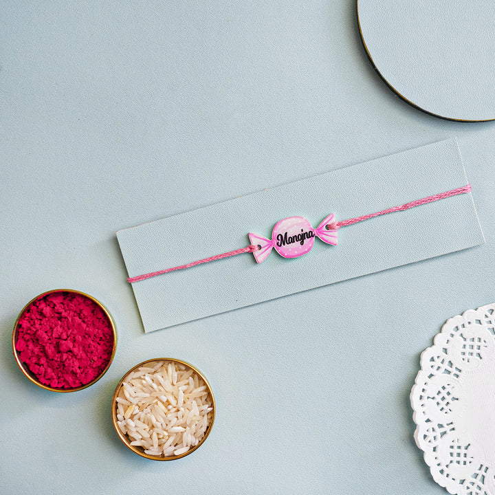 Personalized Handmade Candy Acrylic Kids Rakhi With Roli Chawal - Alternate bracelet on display card with decor