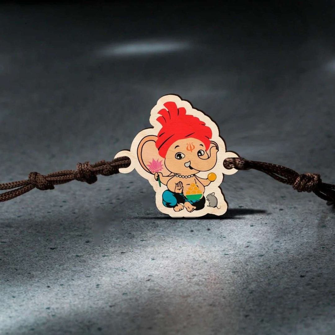 Handmade Ganapati Wooden Kids Rakhi With Roli Chawal - Rakhi on rough stone background