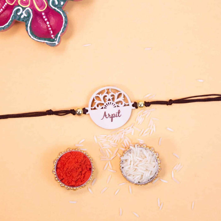 Personalized Handmade Elegant Wooden Rakhi With Roli Chawal - Flat Lay Showing Rakhi with Items