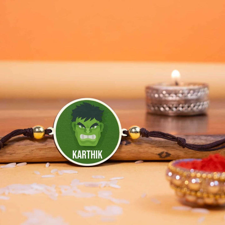 Personalized Handmade Hulk Wooden Kids Rakhi With Roli Chawal - Front View with Ritual Items