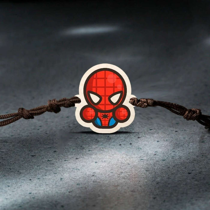Handmade Spiderman Chibi Wooden Kids Rakhi With Roli Chawal - Close-up on Textured Floor