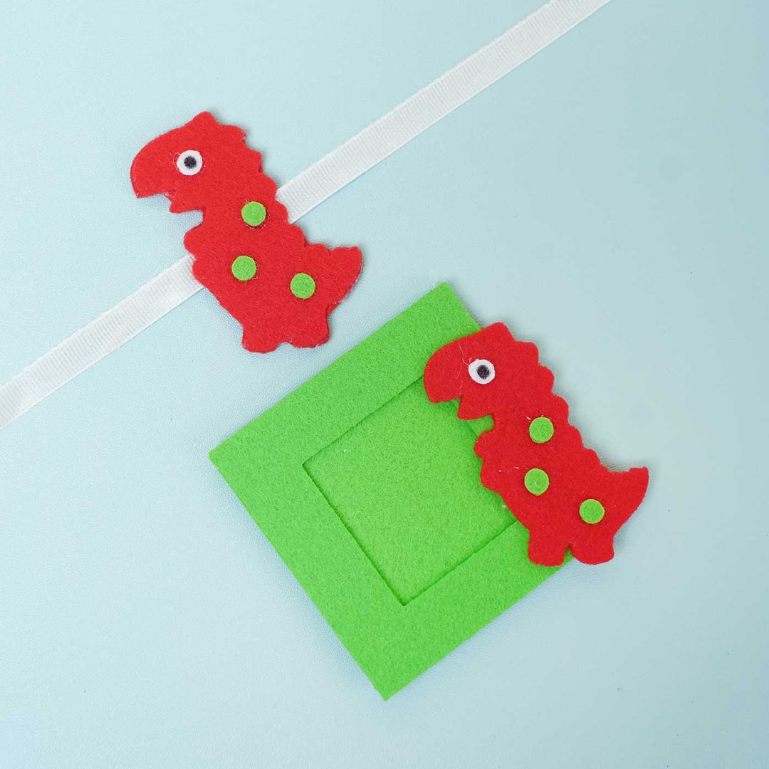 Handmade Red Dinosaur Felt Rakhi Photoframe Magnet With Chocolates Roli Chawal - Flat Lay with Frame and Strap