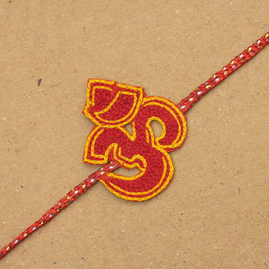 Handmade Beaded Om Rakhi With Roli Chawal - Close-up of red Om rakhi