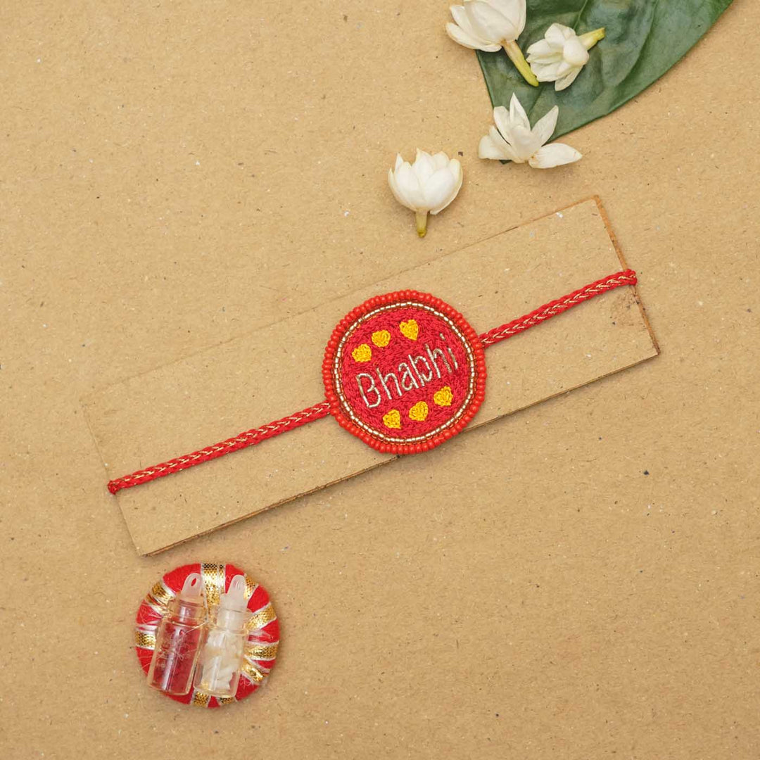 Handmade Beaded Bhabhi Rakhi With Roli Chawal - Flat Lay with Decorative Elements