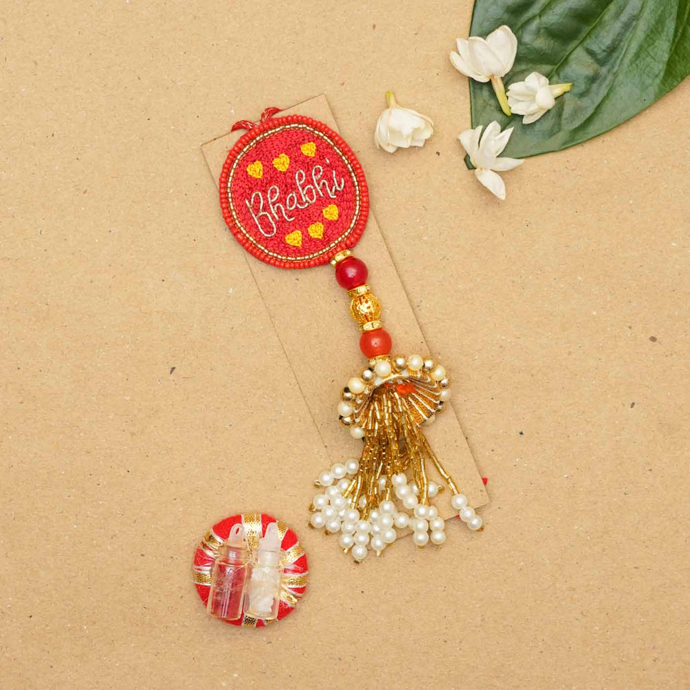 Handmade Beaded Bhabhi Lumba Rakhi With Roli Chawal - Flat lay with Rakhi and accessories