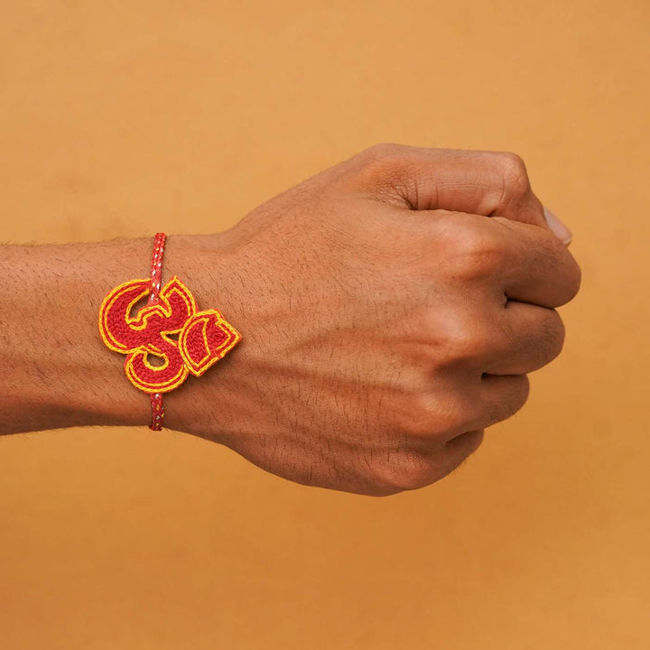 Handmade Beaded Om Rakhi With Roli Chawal - Worn on wrist front view