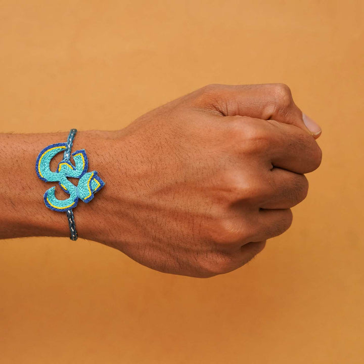 Handmade Beaded Om Rakhi With Roli Chawal - Worn on wrist blue variant