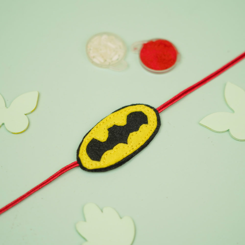 Handmade Batman Theme Felt Kids Rakhi For Brother - Flat lay with surrounding decor