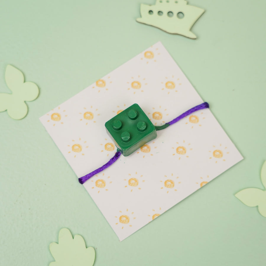 Customized Handmade Lego Block Theme Wax Rakhi For Kids - Flat Lay with Card Background