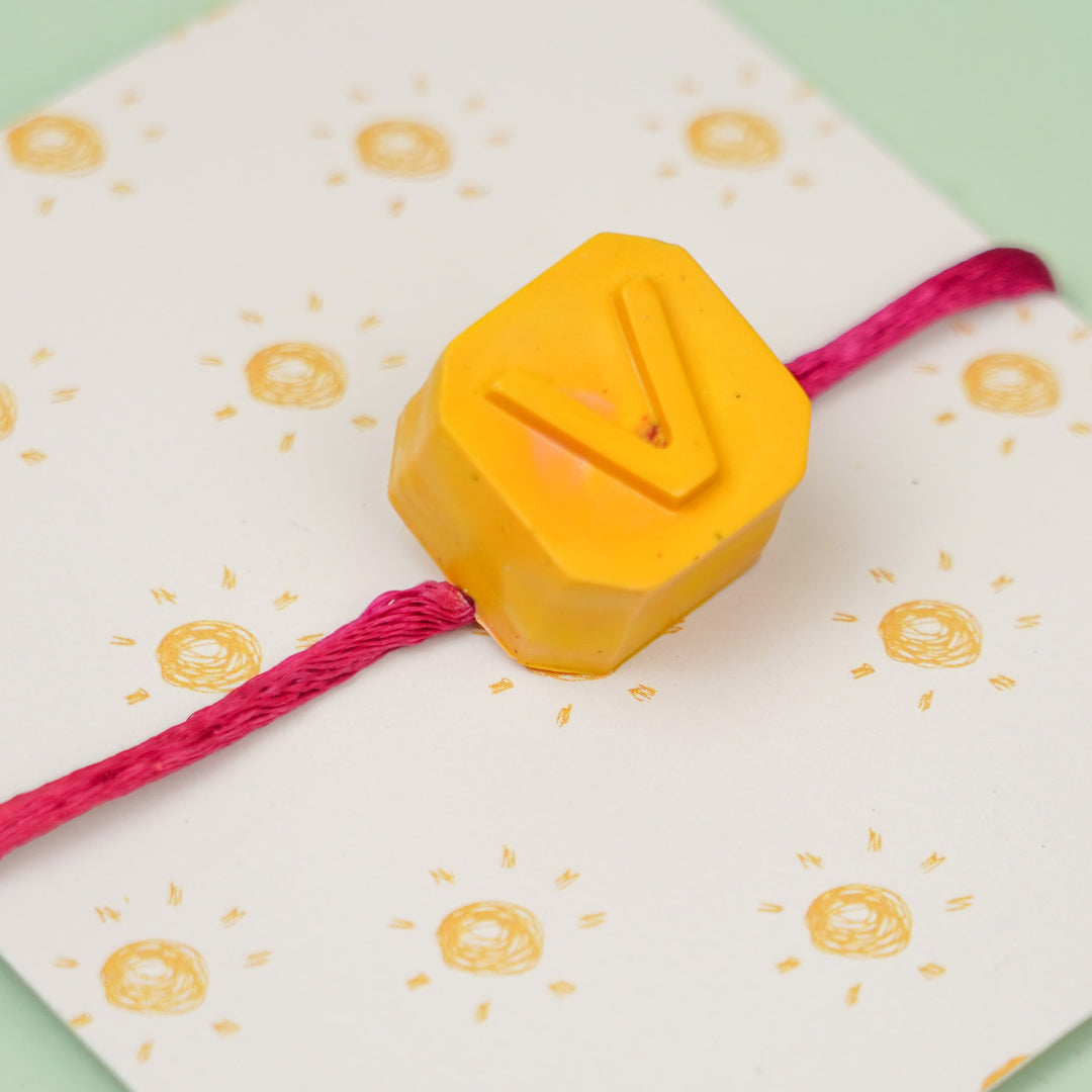 Personalized Handmade Mini Letters Wax Rakhi For Kids - Close-up of yellow "V" charm