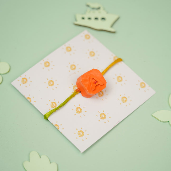 Personalized Handmade Mini Letters Wax Rakhi For Kids - Full product view with "A" charm