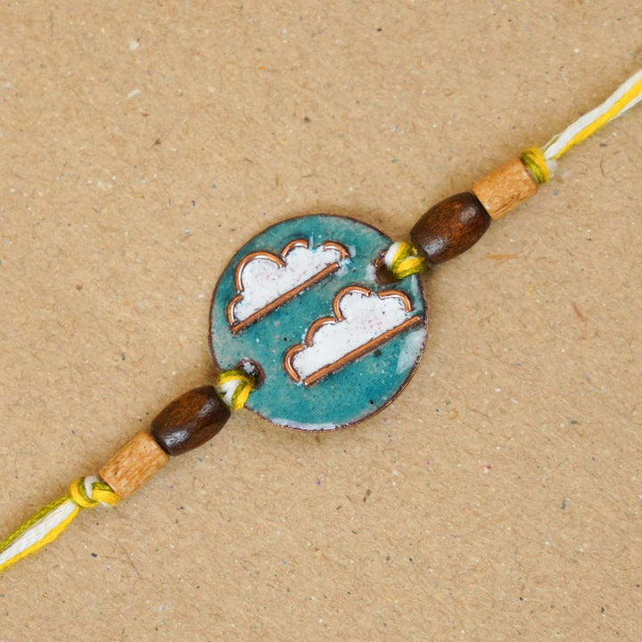 Handmade Baadal Blue Copper Enamel Rakhi With Chocolates And Roli Chawal - Close-up of Rakhi centerpiece