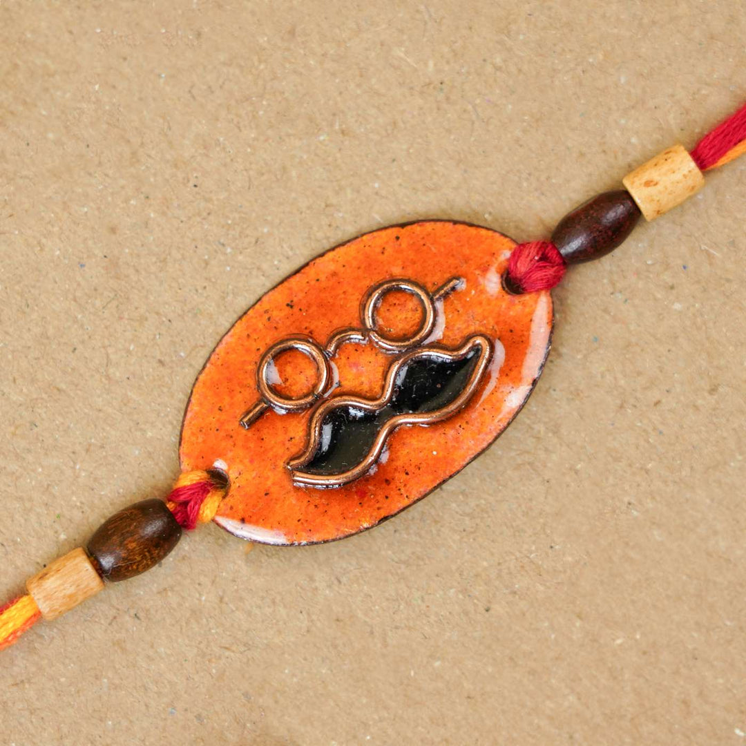 Handmade Mooch Copper Enamel Rakhi With Chocolates And Roli Chawal - Close-up of Rakhi design