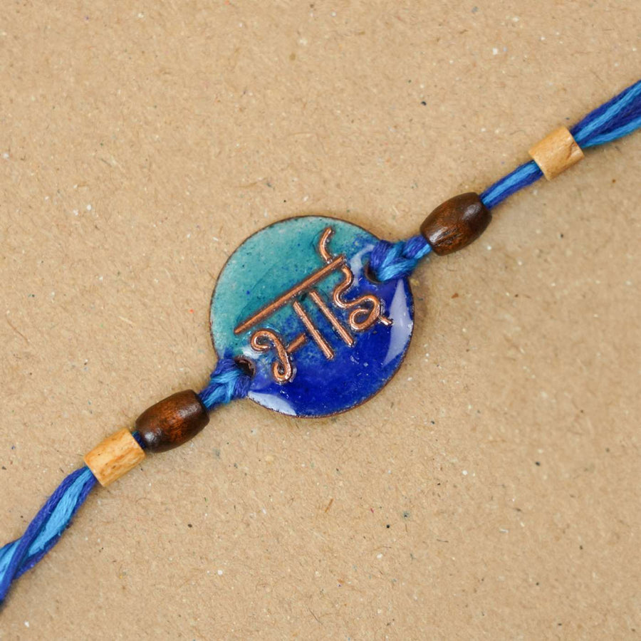 Handmade Bhai Blue Copper Enamel Rakhi With Chocolates And Roli Chawal - Close-up of Rakhi centerpiece