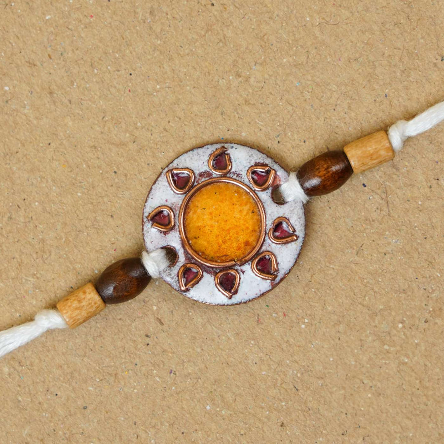 Handmade Sooraj White Copper Enamel Rakhi With Chocolates And Roli Chawal - Close-up of Rakhi centerpiece