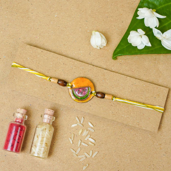 Handmade Tarbooz Red Copper Enamel Rakhi With Chocolates And Roli Chawal - Rakhi on gift card with decorations