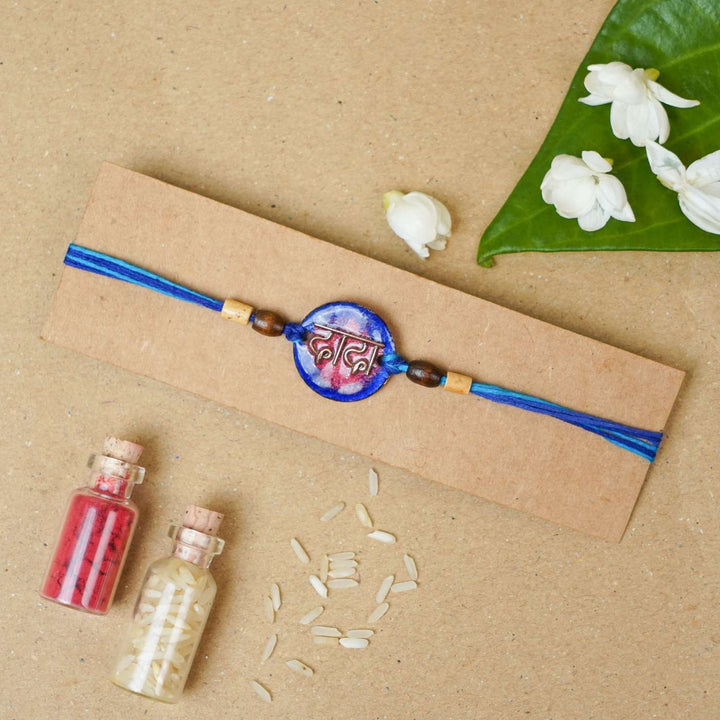 Handmade Dada Blue Copper Enamel Rakhi With Chocolates And Roli Chawal - Rakhi on packaging with decor