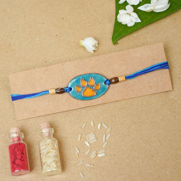 Handmade Pawfect Copper Enamel Rakhi With Chocolates And Roli Chawal - Orange Paw Charm on Card