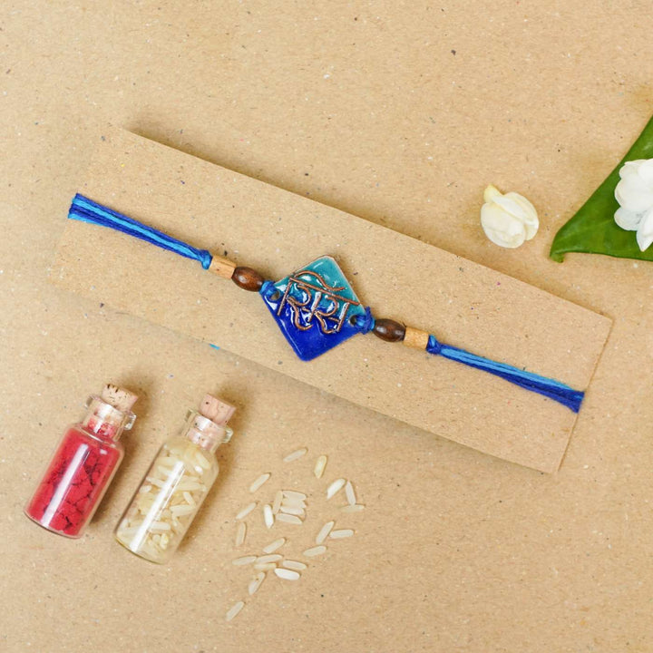 Handmade Sis Blue Copper Enamel Rakhi With Chocolates And Roli Chawal - Rakhi on packaging card