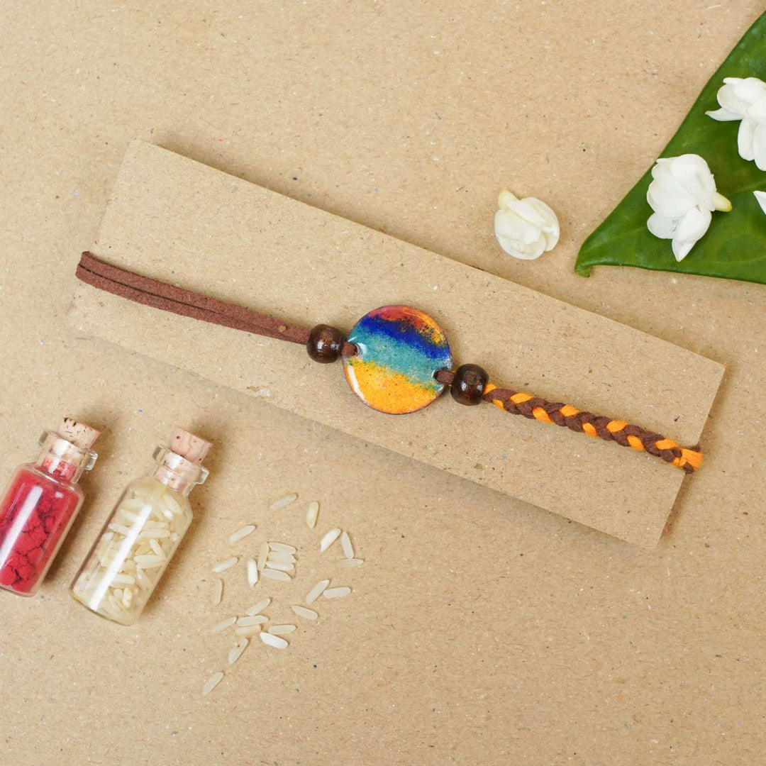 Handmade Indraa Multicolour Copper Enamel Rakhi With Chocolates And Roli Chawal - Bracelet on Kraft Paper Display
